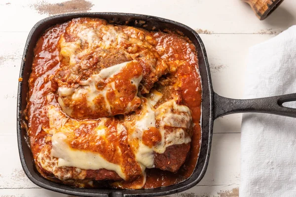 parmegiana Steak üst görünümü de filet Parmegiana olarak bilinen siyah demir tavada 