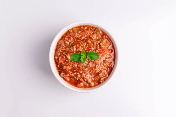 Bolognese (ayrıca Bolognesa veya Bolonhesa olarak da bilin) beyaz arka planda izole beyaz bir kapta sos