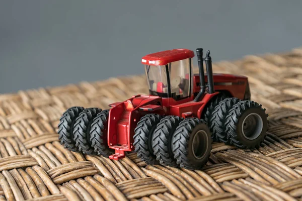 A mini tractor toy on a surface simulating a plantation field