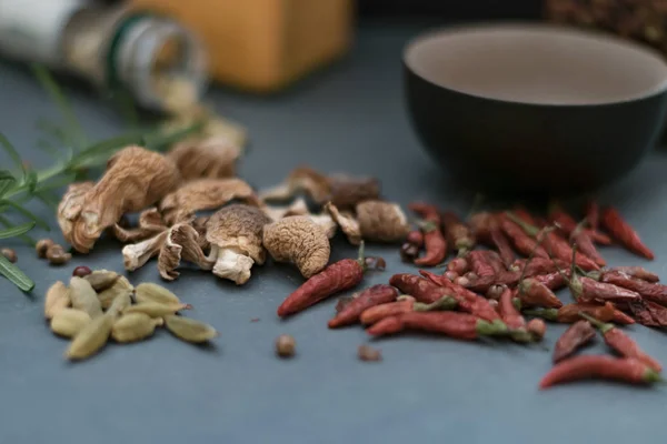 Several spices on gray slate stone. Red peppers, rosemary, dry mushrooms