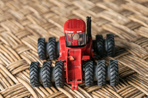 A mini tractor toy on a surface simulating a plantation field