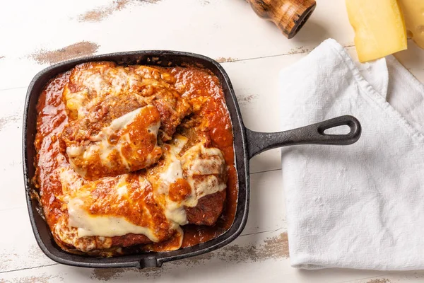 在黑色铁锅中 帕梅吉亚纳牛排的顶视图也被称为 Filet Parmegiana — 图库照片