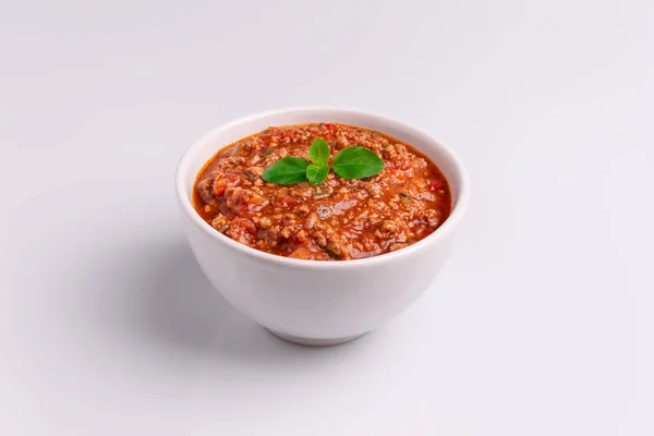 Bolognese (ayrıca Bolognesa veya Bolonhesa olarak da bilin) beyaz arka planda izole beyaz bir kapta sos