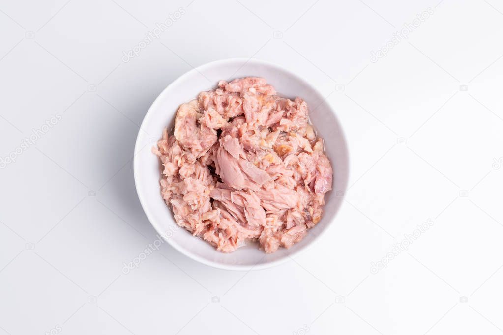 Canned tuna in a white bowl, isolated on white background, top view