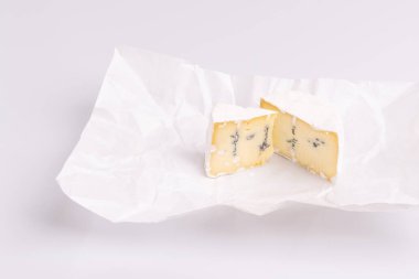 Beyaz yüzeyli mavi peynir, beyaz arka plan, yumuşak ışık, stüdyo fotoğrafı, açı görünümü üzerine izole. Gorgonzola ve camembert / brie peynir karışımı