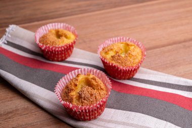 Brezilya yemeği. Queijadinha - tipik brezilya tatlı peynir, hindistan cevizi, yumurta, tereyağı, buğday, kabartma tozu ve ahşap arka plan üzerinde şeker ile yapılan