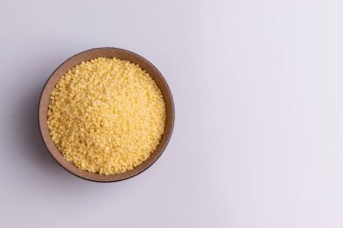 Beyaz arka plan üzerine izole kahverengi seramik kase kuru kuskus