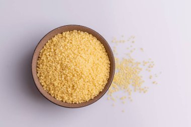 Beyaz arka plan üzerine izole kahverengi seramik kase kuru kuskus