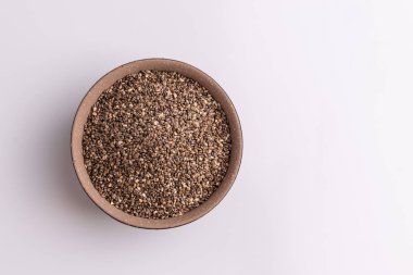 Topraklı chia tohumu (Salvia hispanica) kahverengi seramik bir kapta, beyaz arka plan üzerinde izole