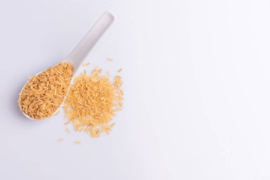 Beyaz arka plan üzerinde beyaz bir kaşık Ham Kahverengi Pirinç Üst görünümü