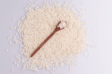 Top view of Italian Risotto rice in a wooden spoon on white background. clipart