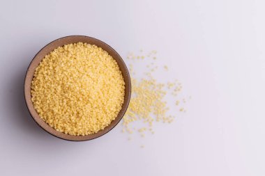 Beyaz arka plan üzerine izole kahverengi seramik kase kuru kuskus