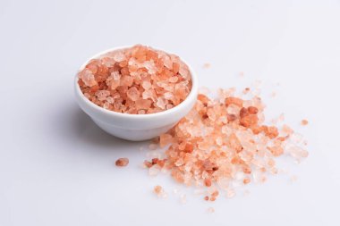 Beyaz arka plan üzerinde beyaz bir kapta pembe himalaya tuzu