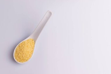 Beyaz arka plan üzerine izole beyaz seramik kaşık kuru kuskus