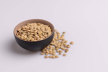 Siyah seramik kase içinde Kuru pişmemiş mercimek açı görünümü, beyaz arka plan üzerinde izole