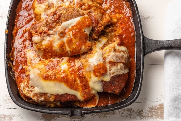 parmegiana Steak üst görünümü de filet Parmegiana olarak bilinen siyah demir tavada 