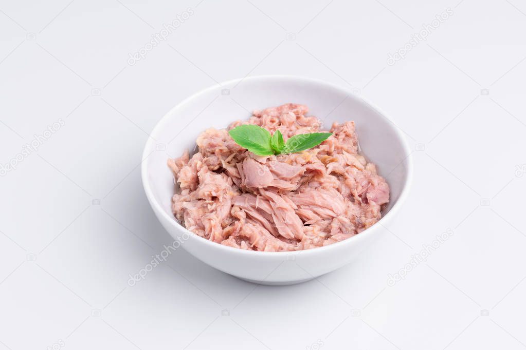 Canned tuna in a white bowl, isolated on white background, angle view