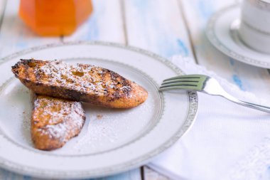 Brezilya usulü tatlı Rabanadas tostları pudra şekeri ve bal küpü, açılı manzara, klasik ahşap masa arka planı. Geleneksel Noel Tavşanları. İspanyol Torrijaları 