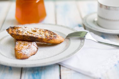 Brezilya usulü tatlı Rabanadas tostları pudra şekeri ve bal küpü, açılı manzara, klasik ahşap masa arka planı. Geleneksel Noel Tavşanları. İspanyol Torrijaları 