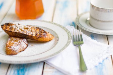 Brezilya usulü tatlı Rabanadas tostları pudra şekeri ve bal küpü, açılı manzara, klasik ahşap masa arka planı. Geleneksel Noel Tavşanları. İspanyol Torrijaları 