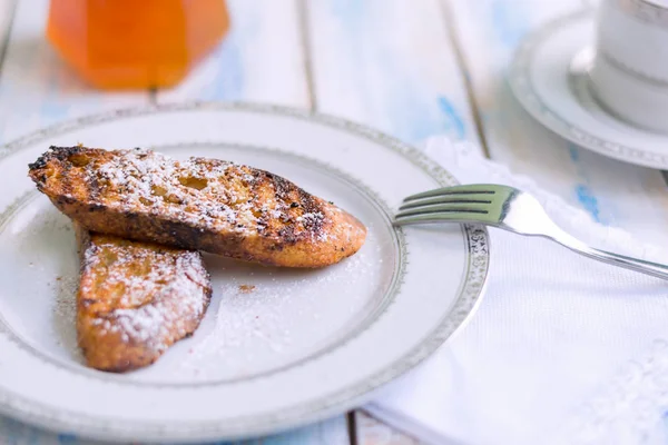 Brezilya usulü tatlı Rabanadas tostları pudra şekeri ve bal küpü, açılı manzara, klasik ahşap masa arka planı. Geleneksel Noel Tavşanları. İspanyol Torrijaları 