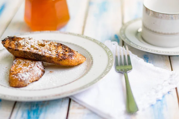 Brezilya usulü tatlı Rabanadas tostları pudra şekeri ve bal küpü, açılı manzara, klasik ahşap masa arka planı. Geleneksel Noel Tavşanları. İspanyol Torrijaları 