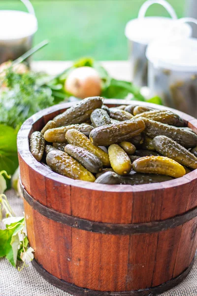Preserved pickled cucumbers with dill and onions in a wooden barrel