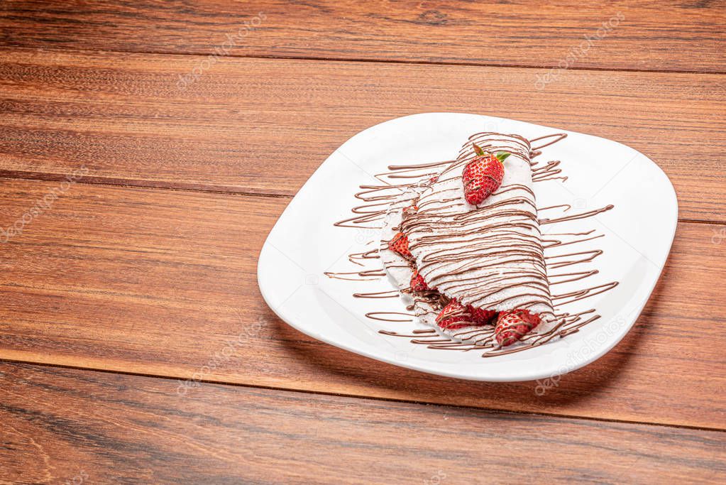 Tapioca filled with strawberries on wooden background. flatbread made from cassava (also known as casabe, bammy, beiju, bob, biju).