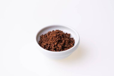 Beyaz arka plandaki kahve fincanında granüle edilmiş kahve.