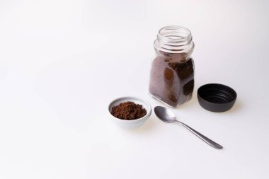 Beyaz arka plandaki kahve fincanında granüle edilmiş kahve.