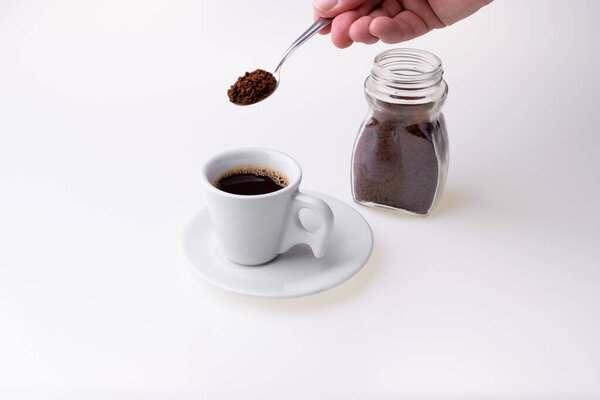 Мгновенный гранулированный кофе из чашки кофе на белом фоне