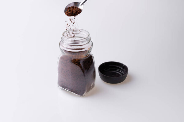 Мгновенный гранулированный кофе из чашки кофе на белом фоне