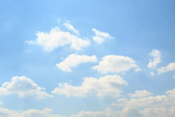 Calm light blue sky with fluffy white clouds in a bright spring day. Ether background.