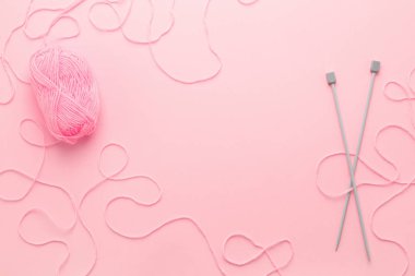 Pembe iplik skein, örgü iğneleri ve çerçeve pembe tablo karışık yün iplik. En iyi görünüm, hobi veya iğne işi kavramı.
