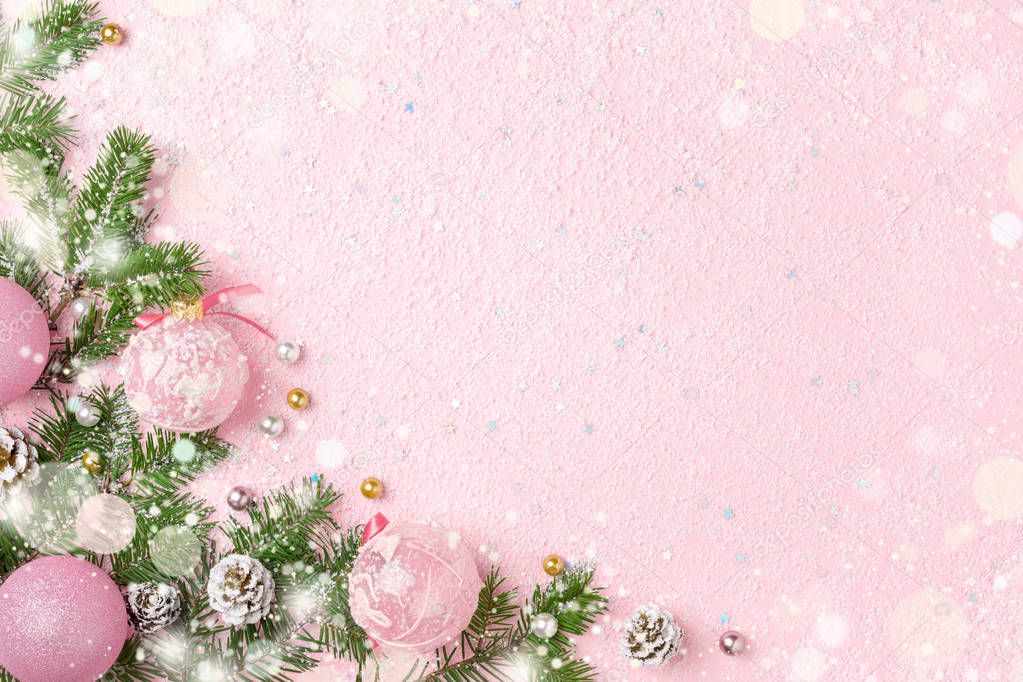 Christmas frame of New Year ornaments, fir and snow on pastel pink. Winter holidays, New Year background with copy space.