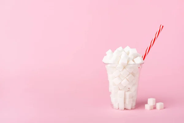 Shake Glass cheio de cubos de açúcar em fundo rosa Conceito de comida insalubre — Fotografia de Stock