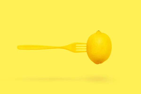 Lewitacja cytrynowa i widelca na pastelowe żółte tło minimalny letni koncept. — Zdjęcie stockowe