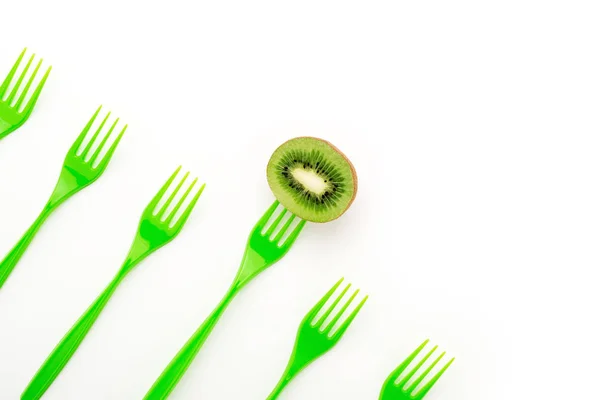 Kiwi e garfos verdes em linha no fundo branco com spase de cópia . — Fotografia de Stock