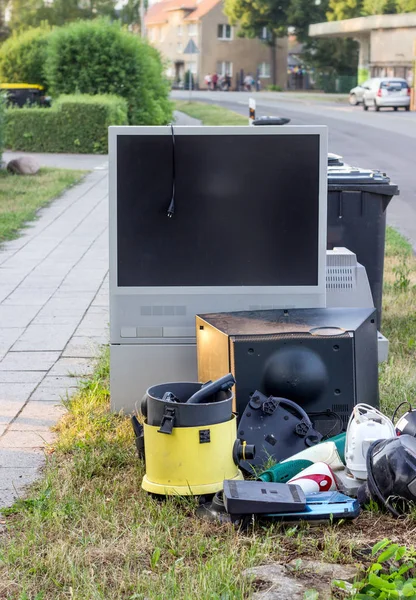 electronic garbage with a television, vacuum cleaner and other electrical appliances on the roadside
