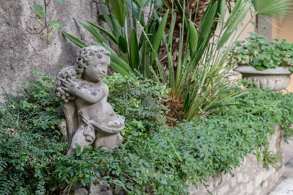 壁の緑の植物と小さな彫刻の庭 — ストック写真