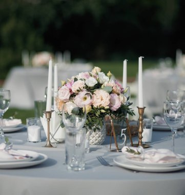 Düğün için mavi pastel bazı mumlar ve bir numara 5 işareti ile birlikte zarif masa kurulumu