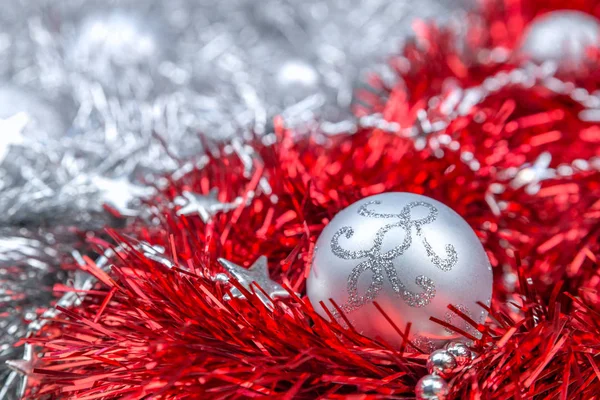 Adornos de Navidad de plata sobre oropel rojo — Foto de Stock