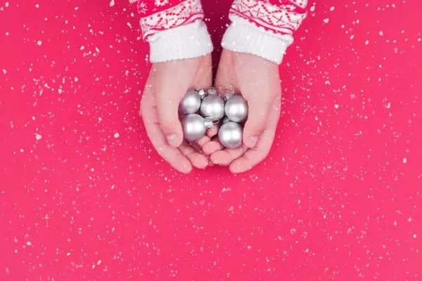 Kinderhand Hält Silberne Christbaumkugeln Auf Rotem Hintergrund — Stockfoto