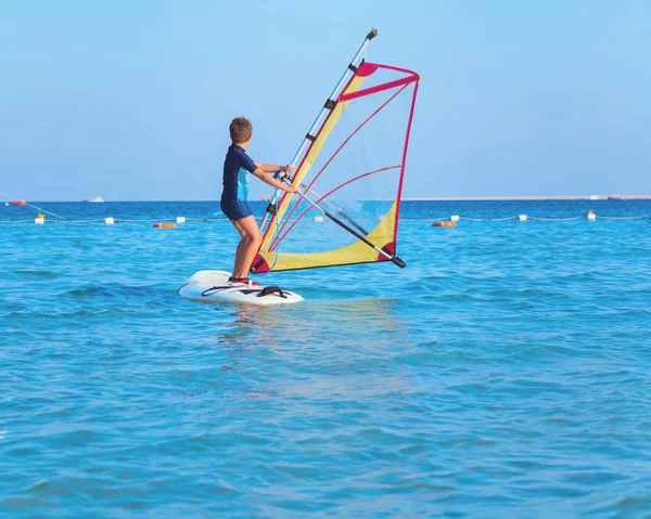 Çocuk açık deniz sularında windsurf öğrenmek