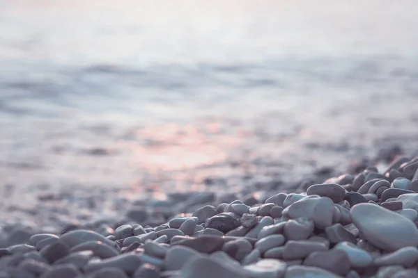 Wet pebble stones and water at morning seaside