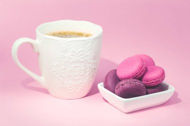 Birkaç lezzetli pembe macarons kase ve kahve