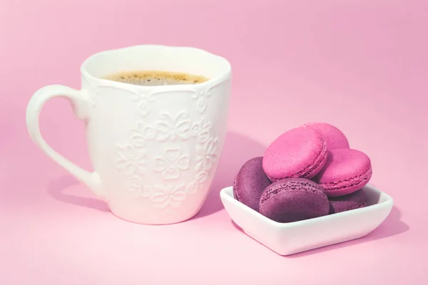 Mehrere leckere rosa Macarons in Schüssel und Kaffee — Stockfoto