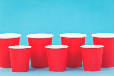 Plastik kavramının ötesinde, kopya alanı ile mavi arka plan üzerinde kırmızı kağıt bardak satırlar