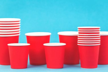 Plastik kavramının ötesinde, kopya alanı ile mavi arka plan üzerinde kırmızı kağıt bardak satırlar