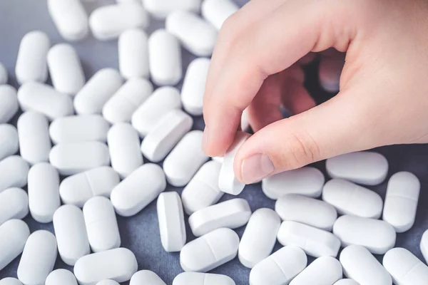 Arka plan beyaz tablet bir tableti toplama bir eliyle masanın üzerinde. Sağlık ve tıp kavramı kopya alanı ile